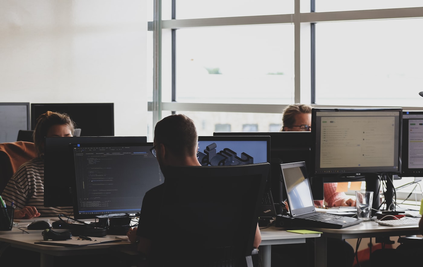 An engineering floor with people working across multiple monitors