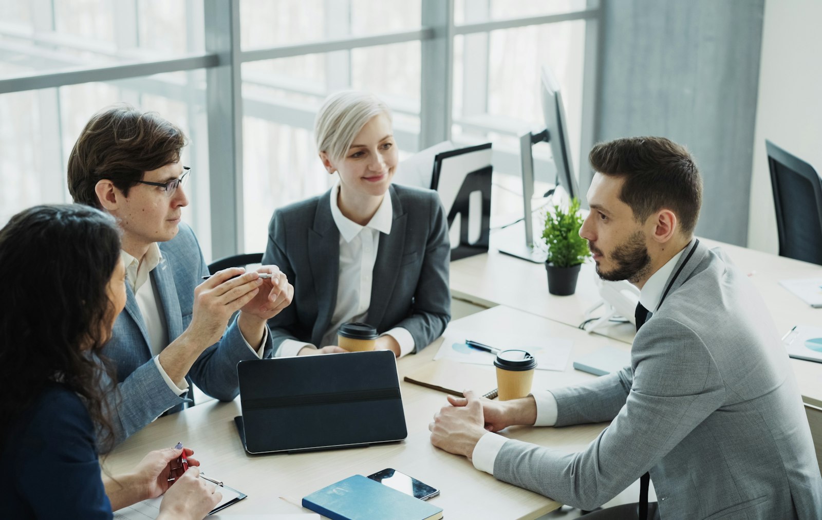 Four colleagues discussing plans around a meeting table
